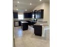 Modern kitchen boasts dark cabinetry, stainless steel appliances, and granite countertops at 4224 Sagefield Dr, Harmony, FL 34773