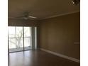 Empty living room featuring wood floors, neutral-toned walls, and a sliding glass door at 495 Las Cortes Ln # 206, Orlando, FL 32824