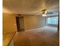 Spacious carpeted living room with ceiling fan and large window for lots of light at 5164 Conroy Rd # 1526, Orlando, FL 32811