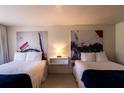 Bright hotel room with two beds, white linens, unique artwork, and hardwood floors at 5245 W Irlo Bronson Memorial Hwy # 151, Kissimmee, FL 34746