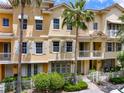 Charming townhome exterior with lush landscaping, palm trees, shutters, and white picket fence offers curb appeal at 724 Greybull Run, Lake Mary, FL 32746