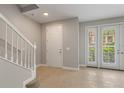 Inviting foyer with tile flooring, a staircase, and natural light from the double doors at 724 Greybull Run, Lake Mary, FL 32746
