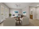 Bright living room boasts tile floors, white furniture, decorative pillows, wall art and a ceiling fan at 724 Greybull Run, Lake Mary, FL 32746