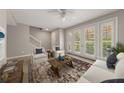 Bright living room boasts tile floors, white furniture, large windows with natural light, and an area rug at 724 Greybull Run, Lake Mary, FL 32746