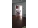View of dining area adjacent to living room, featuring hardwood floors and kitchen view at 9315 9Th Ave, Orlando, FL 32824