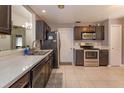 Open kitchen with stainless steel appliances, dark wood cabinets, and neutral countertops at 1023 Royal Oaks Dr, Apopka, FL 32703