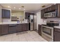 Functional kitchen with stainless steel appliances, dark wood cabinets, and a pass-through to another room at 1023 Royal Oaks Dr, Apopka, FL 32703