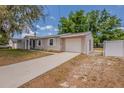 Charming single-story home with an attached garage and concrete driveway in the front yard at 1084 Doyle Rd, Deltona, FL 32725
