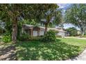 Landscaped front yard featuring mature trees with a peek at the house and two-car garage at 1100 Oday Dr, Winter Springs, FL 32708