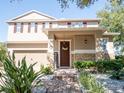 Inviting two-story home featuring manicured landscaping and a welcoming front porch with decorative wreath at 11742 Chateaubriand Ave, Orlando, FL 32836
