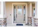 Charming front entryway with decorative door, sidelights and stone-accented porch columns at 11957 Vermillion Ave, Windermere, FL 34786