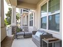 Inviting front porch featuring stone accents, comfortable seating, and ample natural light at 11957 Vermillion Ave, Windermere, FL 34786