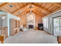 Inviting living room featuring vaulted ceilings, stone fireplace, and sliding doors to the outdoor area at 12454 S Lake Mary Jane Rd, Orlando, FL 32832
