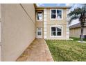 Rear exterior showcasing a walkway, access door, and manicured lawn next to the home at 13054 Prairie Meadows Dr, Orlando, FL 32837