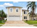Beautiful two-story home with a manicured lawn, brick driveway, and meticulously maintained landscaping at 13054 Prairie Meadows Dr, Orlando, FL 32837