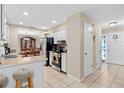 Bright kitchen featuring white cabinets, stainless steel appliances, and a breakfast bar, seamlessly connecting to the dining area at 1503 Canterbury Cir, Casselberry, FL 32707