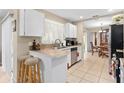 Well-lit kitchen area with white cabinetry, stainless steel dishwasher and views to the dining room at 1503 Canterbury Cir, Casselberry, FL 32707