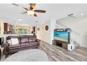 Comfortable living room with hardwood floors, ceiling fan and large tv with a beach scene at 171 Mcleods Way, Winter Springs, FL 32708