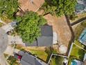 Aerial view of a home with a dark roof, a partially shaded yard, and a circular feature at 1862 Spreakley Ct, Orlando, FL 32837