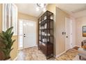 Bright foyer featuring stylish tile flooring, front door with sidelights, and a decorative storage shelf at 21529 Prince Albert Ct, Leesburg, FL 34748