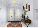 Inviting foyer with double doors, console table, decor, and tile flooring at 235 Hollingshead Loop, Davenport, FL 33896