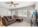 Comfortable living room with large window, ceiling fan, and a brown sectional sofa at 2935 Arcata Ln, Orlando, FL 32817