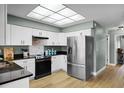 Well-lit kitchen featuring white cabinets, stainless steel appliances, and durable granite countertops at 307 Coble Dr, Longwood, FL 32779