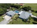 Aerial view of gray home with screened in pool, detached garage, RV parking and spacious lot at 4170 Packard Ave, St Cloud, FL 34772