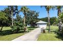 Long driveway with partial home view surrounded by mature trees and green grass at 4170 Packard Ave, St Cloud, FL 34772