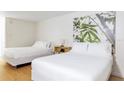 Bright bedroom with white linens, minimalist decor, two beds, and a nature-inspired print at 5245 W Irlo Bronson Memorial Hwy # 170, Kissimmee, FL 34746