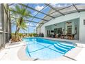Resort-style screened-in pool area with a custom design, complemented by lounge seating and a lush tropical palm at 5494 Glen Oak Pl, Sanford, FL 32771