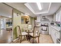 Eat-in kitchen features stainless steel appliances, white cabinets and tile backsplash at 5501 Vance Ave, Orlando, FL 32810