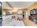 Open concept living room with a large white sectional, mirrors and eat-in kitchen views at 5501 Vance Ave, Orlando, FL 32810