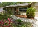 Inviting front entrance with stone accents, landscaping, and a walkway leading to a red front door at 622 Alton Rd, Winter Springs, FL 32708