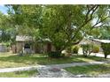 Charming single-story home featuring a stone facade, mature trees, and a well-manicured lawn at 622 Alton Rd, Winter Springs, FL 32708