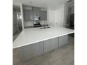 Kitchen island featuring grey cabinets, a white countertop, and a stainless steel faucet at 734 Via Como St, Poinciana, FL 34759