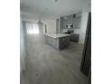 Open-concept kitchen featuring a large island, gray cabinetry, and modern appliances at 734 Via Como St, Poinciana, FL 34759