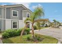 Inviting townhome featuring manicured landscaping, a young palm, and convenient parking at 7554 Oak Spring Ln, Davenport, FL 33837