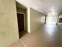Hallway with a brown front door on the left, leading to the unit entrance and an outdoor staircase visible at the end at 814 Crest Pines Dr # 915, Orlando, FL 32828