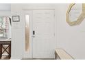 Bright foyer features a white front door with sidelight, wood floors and modern decor at 957 Orange Cosmos Blvd, Davenport, FL 33837