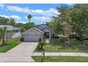 Beautiful single-Gathering home with a lush lawn, a two-car garage, and a welcoming entrance walkway at 1003 Hart Branch Dr, Oviedo, FL 32765