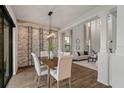 Elegant dining room featuring a stone accent wall, modern chandelier, and bright natural light at 1151 Wildmeadow Run, Winter Park, FL 32792