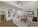 Bright, open-concept living room with soaring ceilings, wood floors, and access to dining area and staircase at 1151 Wildmeadow Run, Winter Park, FL 32792