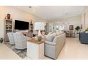 Bright living room with tile flooring, neutral walls, and modern furnishings that flow into the adjacent dining area at 1265 Zeek Ridge St, Clermont, FL 34715