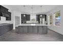 Modern kitchen featuring gray cabinets, a large center island, stainless steel appliances, and sleek countertops at 12863 Harvest Rain Ave, Winter Garden, FL 34787