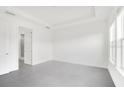 Bright main bedroom with neutral walls, tile floors, tray ceiling, and large windows at 12869 Harvest Rain Ave, Winter Garden, FL 34787