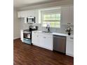 Modern kitchen with white cabinetry, stainless steel appliances, and a large window providing natural light at 1310 Polk City Rd, Haines City, FL 33844