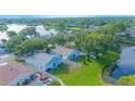 Aerial view of homes near a tranquil pond and lush green spaces in a suburban neighborhood at 13434 Mallard Cove Blvd, Orlando, FL 32837