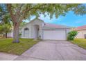 Charming single-story home with a well-manicured lawn and a large tree in the front yard at 13434 Mallard Cove Blvd, Orlando, FL 32837