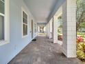 Covered porch featuring brick flooring, columns, and a view of the well-maintained landscaping at 13662 Behring Ave, Orlando, FL 32827